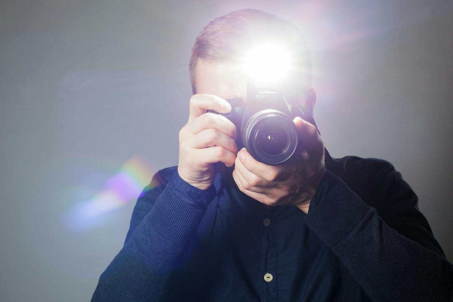 Mann som fotograferer med kamera og innebygd blits